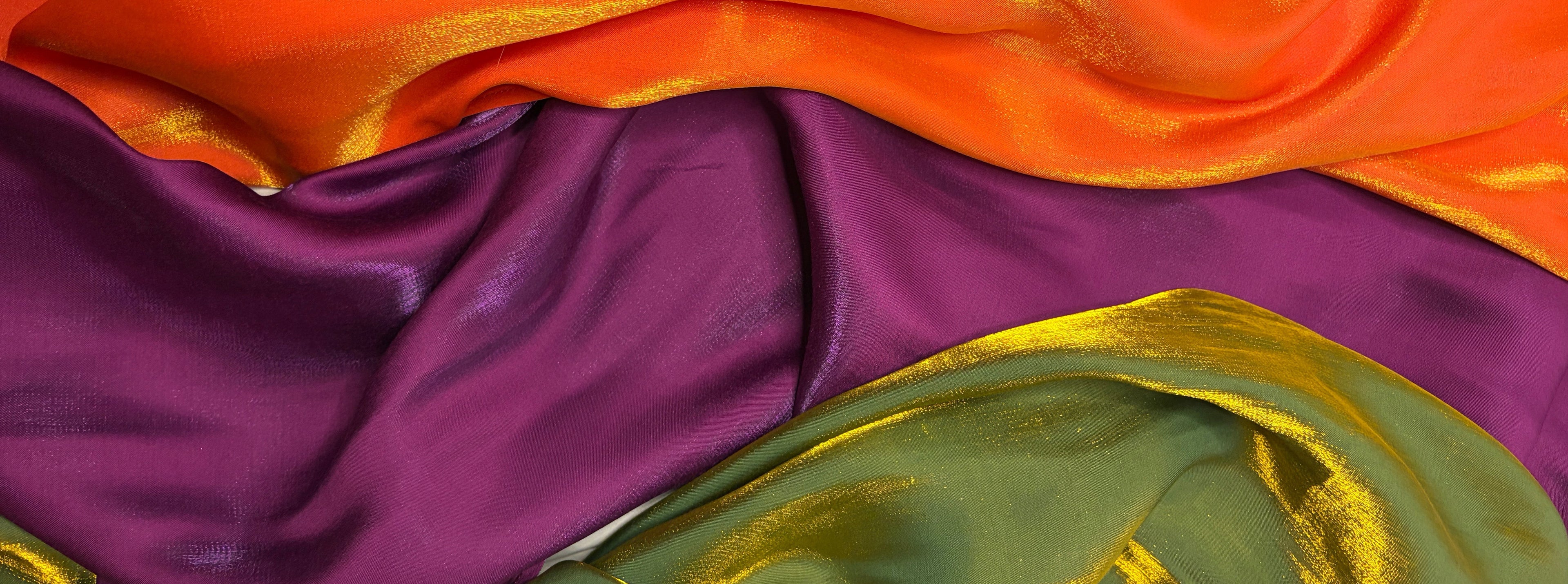 Close-up of colorful fabric with gold accents in purple, green, and orange.